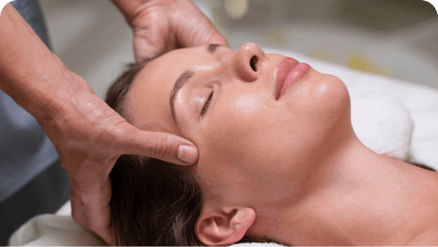 Close-up of a person receiving a facial temple massage.