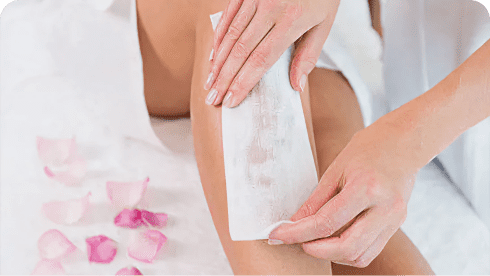Close-up of a leg being waxed.