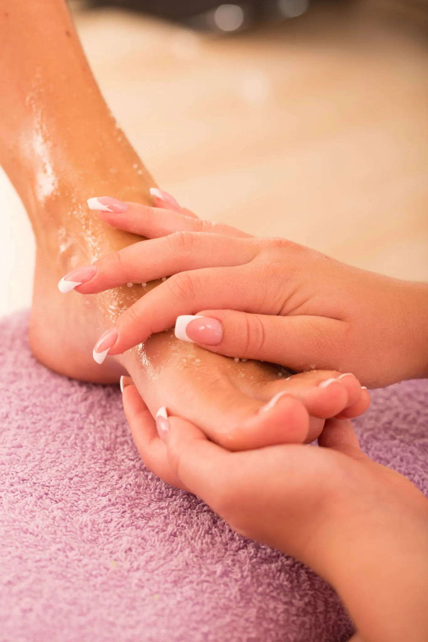 Nail technician performing exfoliating foot scrub and callus removal during a spa pedicure treatment in San Antonio TX