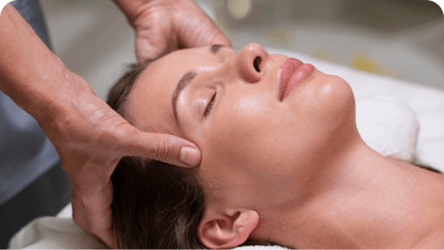 Close-up of a person receiving a facial temple massage.